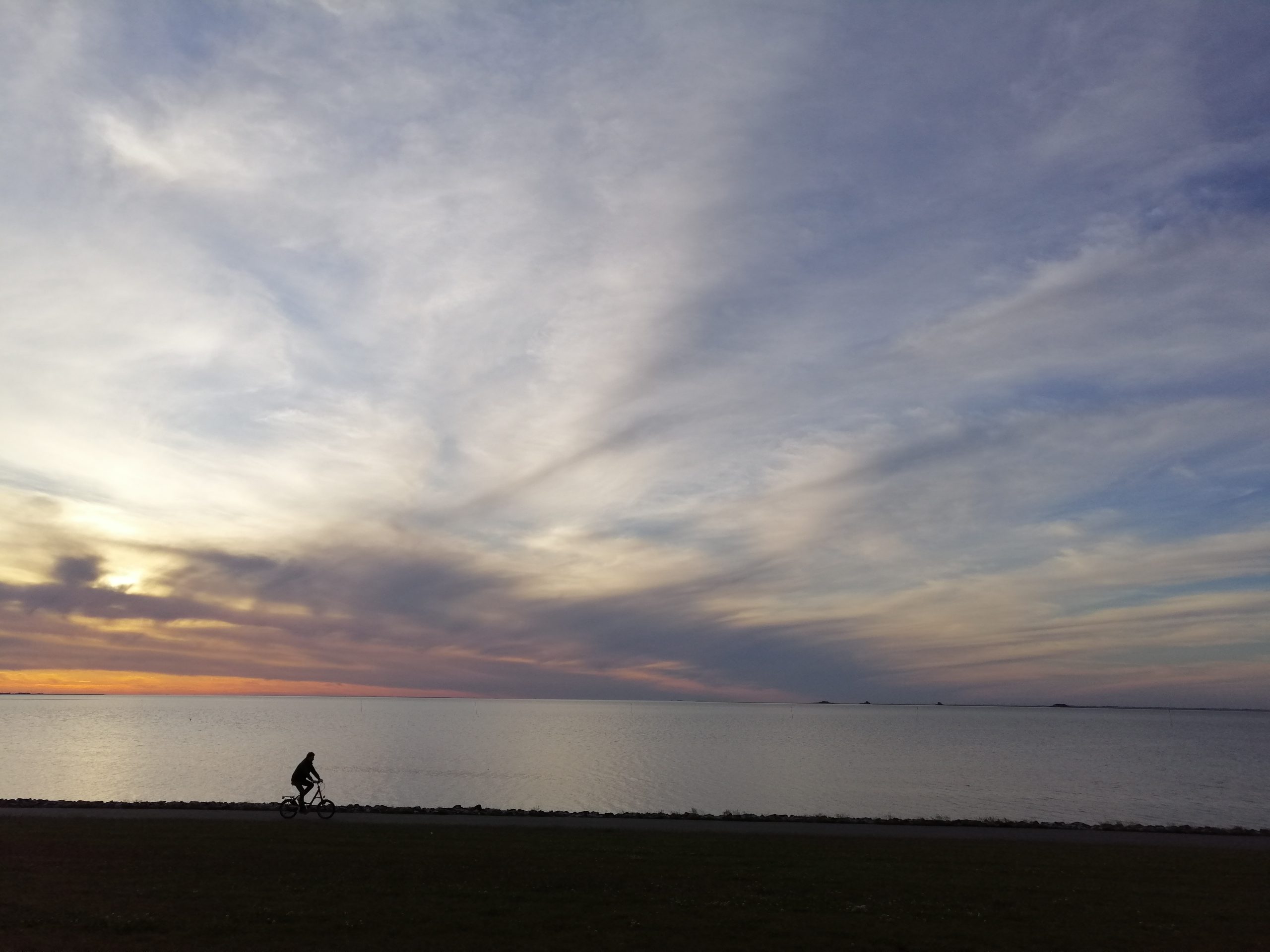 Morgendämmerung: ein Fahrradfahrer an einem See